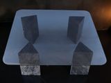 a glass table with three pieces of marble on it