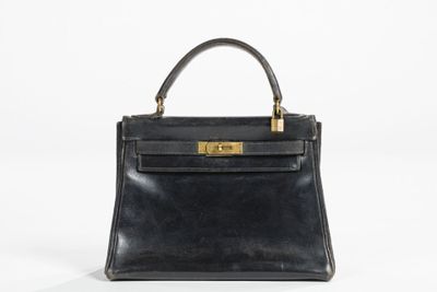 a black leather handbag with gold hardware on the handle