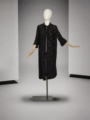 une photo d'un mannequin vêtu d'un manteau noir et d'un pantalon noir