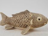 a gold fish figurine sitting on a white surface