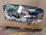 a cardboard box with clothes in it sitting on a pallet