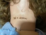 a close up of a doll ' s neck with a tattoo on it
