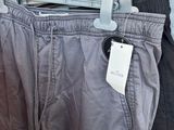 two men ' s pants hanging on a rack in a clothing store
