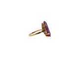a close up of a purple stone ring on a white background