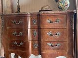 a wooden chest of drawers with a lamp on top of it