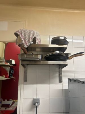 un homme debout sur une cuisinière dans une cuisine