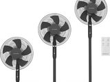 trois ventilateurs noirs et blancs équipés de télécommandes, sur fond blanc