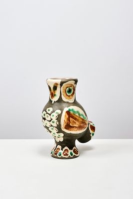 un vase en forme de chouette posé sur une table blanche