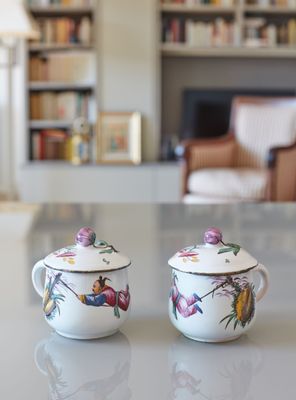 deux tasses posées sur une table devant une bibliothèque