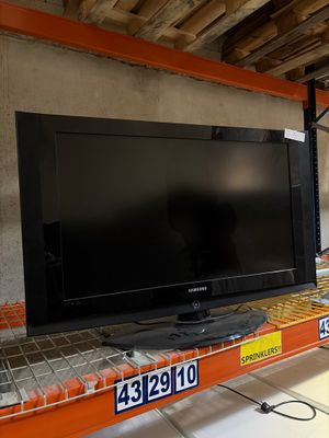 un téléviseur à écran plat posé sur une étagère dans un magasin