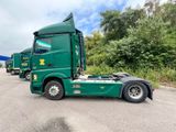 a green semi truck that is parked in a lot