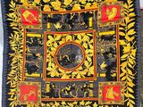 a close up of a black and yellow quilt with flowers and birds on it
