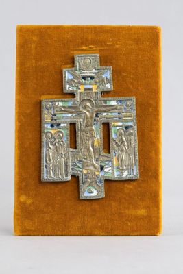 une image représentant une croix en argent sur laquelle figure Jésus, posée sur une surface en velours