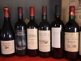 several bottles of red wine are lined up on a table