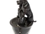 a statue of a dog sitting in a bowl on a table