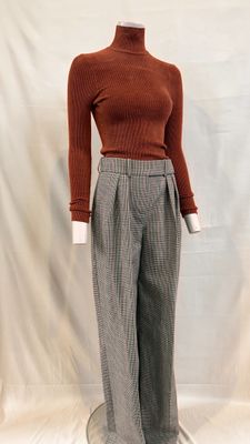 une photo d'un mannequin portant un pull marron et un pantalon gris
