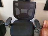 une chaise de bureau portant un numéro au dos, dans une pièce