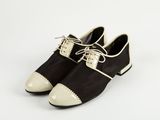 une paire de chaussures noires et blanches posées sur une surface blanche