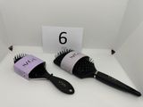 two hair brushes sitting on a table next to each other