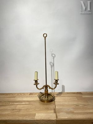 chandelier en laiton plaqué, avec deux bougies, posé sur une table en bois