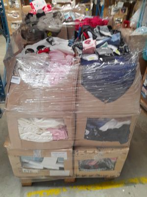 Des cartons de vêtements sont empilés les uns sur les autres dans un entrepôt