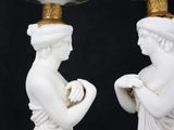 pair of white and gold vases with a woman holding a flower