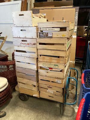 a stack of boxes on a cart next to a toilet