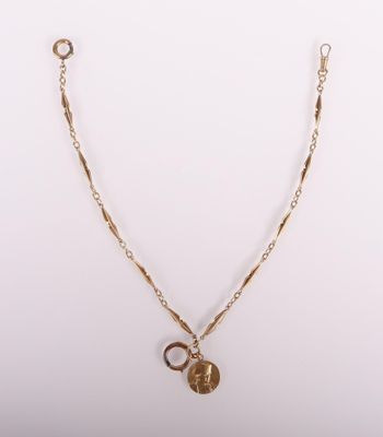 a gold necklace with a coin and a chain on a white background