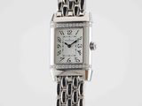 a close up of a wrist watch with a chain around it