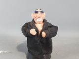 une figurine représentant un homme vêtu d'une veste noire et portant des lunettes de soleil
