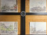 quatre tableaux accrochés au mur d'un immeuble sur lequel se trouve une horloge