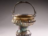 un vase ancien en argent muni d'une anse, sur un fond blanc