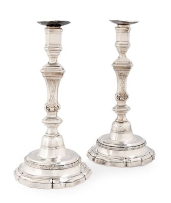pair of antique silver candlesticks on stand on white background