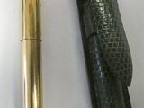 a gold pen and a black case on a white surface
