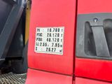 a close up of a red truck with a number plate
