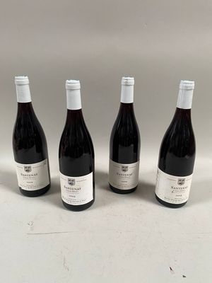quatre bouteilles de vin sont alignées sur une surface blanche