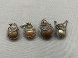 three small silver and gold ornaments are sitting on a table