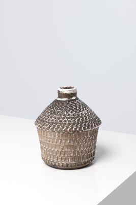 une photo d'un vase marron et blanc posé sur une table blanche