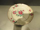 une assiette blanche ornée de fleurs roses, posée sur une table