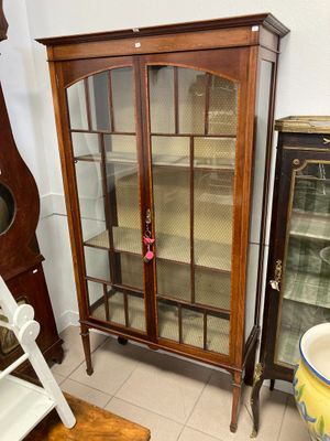 une armoire à portes vitrées dans un coin de la pièce