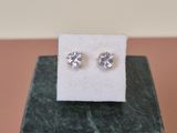 a close up of a pair of earrings sitting on top of a marble block