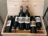 bottles of red wine in a wooden box on a table