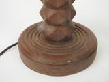a wooden table lamp that is on a white surface