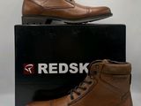 men ' s brown leather boots on display in front of a box