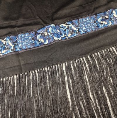 un gros plan sur une jupe noire ornée de fleurs bleues