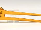 a yellow hair clip with a flower design on it