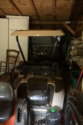 une photo d'un garage dans lequel se trouve une tondeuse à gazon
