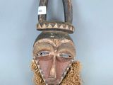 une image d'un masque en bois accroché au mur