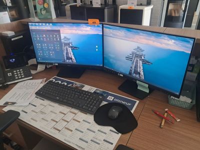 un bureau équipé de deux écrans et d'un clavier