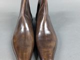 a pair of brown leather ankle boots sitting on top of a gray surface